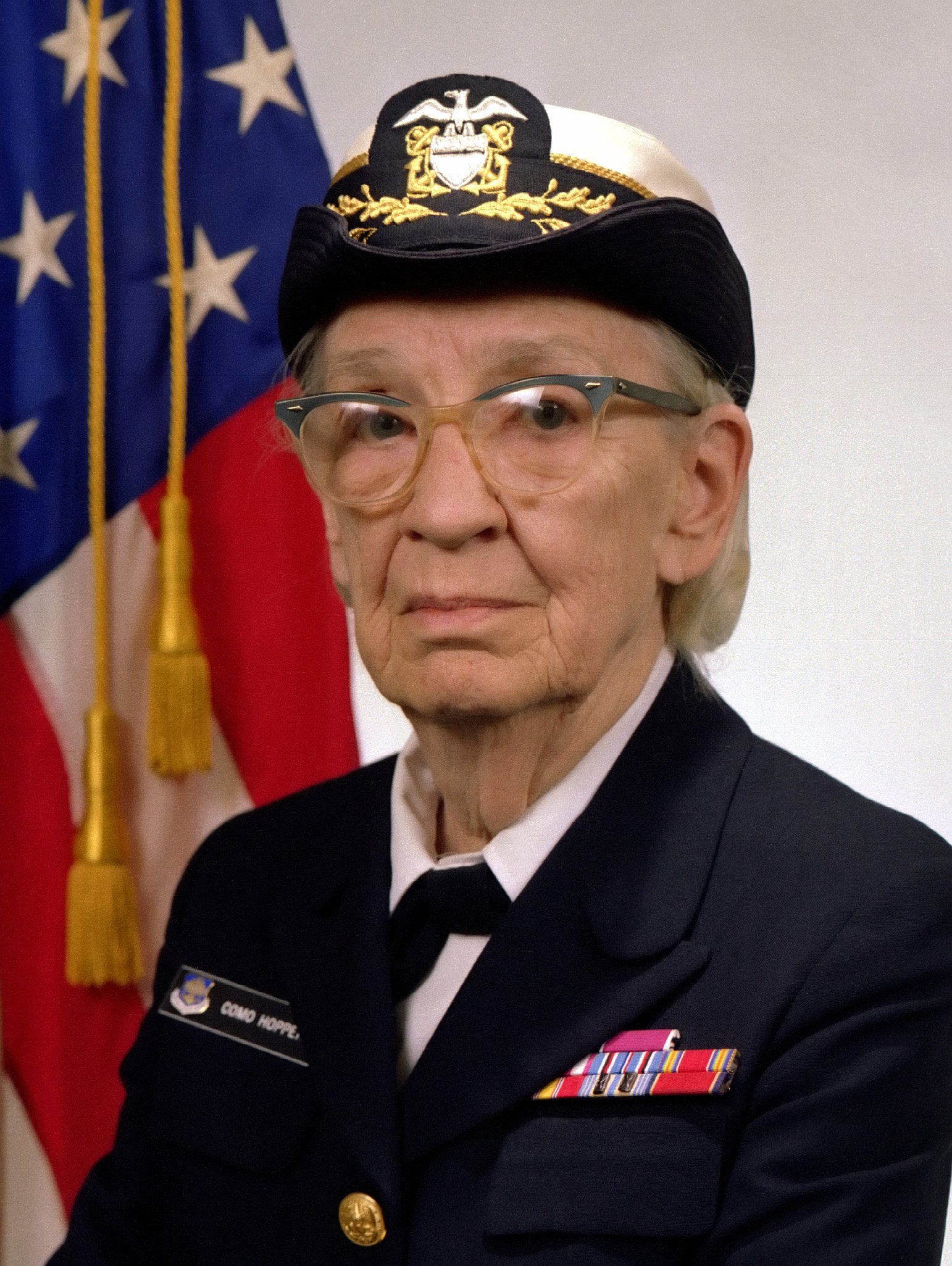 Senior naval officer in uniform with flag background