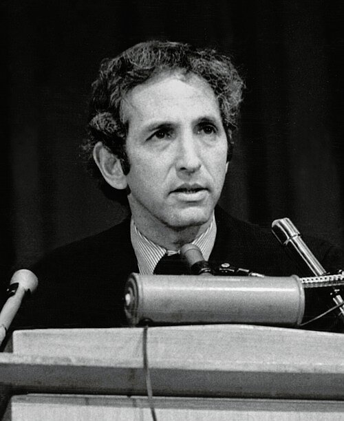 Man speaking at podium with microphones